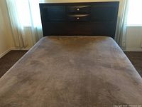 Full view of the queen size bed frame with dark wood headboard featuring 2 drawers and the mattress support slats in place