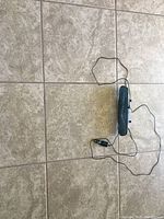 Top-down view of black rearview mirror dash camera with attached power cable