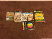 Lot showing a 240-sheet Crayola construction paper pack, Astrobrights color paper, and five sheets of themed stickers including people in various outfits, vehicles, and animals.