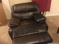 Front view of dark brown leather recliner showing cushioned seat and padding.