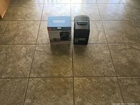 Mini Igloo cooler displayed next to its original box on a tiled floor.