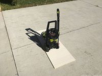 Sun Joe pressure washer on a concrete driveway, showing overall unit and handle.