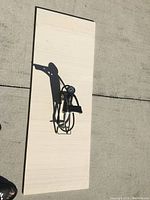 Small black Bell foot pump shown on wood board on concrete. Foot pedal, pressure gauge and hose visible.