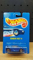 Front view of the Hot Wheels Zender Fact 4 car in original sealed blister pack with blue card featuring Hot Wheels logo and car illustration.