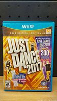 Front cover of Just Dance 2017 Gold Edition for Wii U showing game title, gold background, and subscription offer.