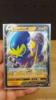 Front view of a single holo Grapploct V Pokemon card displaying stats, artwork, and move details.