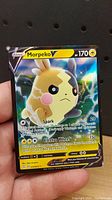 Front view of Morpeko V Pokémon TCG card showing artwork, HP and attack info.