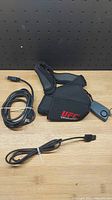 Photo shows two PS3 gaming accessories: one neoprene strap with UFC branding and a cable, the other a USB to PlayStation connector cable.