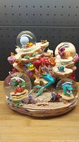Full view of Disney The Little Mermaid multi-globe figurine with Ariel, Flounder, Sebastian, and other underwater details on sandy base.