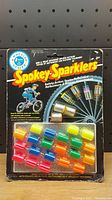 Front view of Spokey Sparklers vintage sealed package with 8 colorful wheel reflectors attached to card.