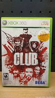 Front cover of The Club video game case for Xbox 360 showing title, characters and artwork.