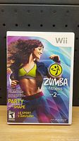 Front cover of Nintendo Wii Zumba Fitness 2 game showing active woman in workout clothing and game title.