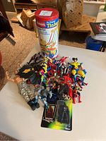 Photo of action figures and vintage Tinkertoy set on table from above, showing assortment and packaging