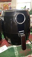 Black Gourmia air fryer with handle and logo, placed on table