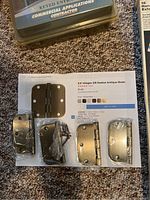 Four brass 3.5-inch radius hinges with hardware on carpet with a printed price sheet underneath.