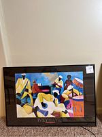 Colorful framed print featuring a group of musicians playing piano, saxophone, drums, trumpet, and other instruments with black matting and frame.