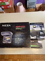 Photo showing boxed NESA NSMD-8484 8.4 inch TFT-LCD TV with DVD player combo alongside boxed dash cam and VIZR heads up display