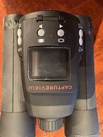Close-up of the Meade Capture View CV-6 digital camera binocular showing control buttons and LCD screen.