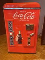 Front view showing Coca-Cola logo, bottle opener, coin slot decals, and bottle artwork.