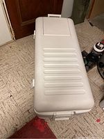 Top angled view of the large white Igloo cooler showing the textured lid with inset hatch and the handle on the end.