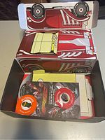 Photo of inner contents of the Loot Crate box showing pop-top frisbees and folded cardboard red car model.
