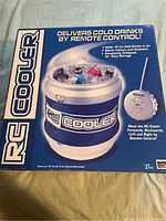 Front view of the box showing the remote controlled cooler and remote control graphic with claims that it delivers cold drinks by remote control.
