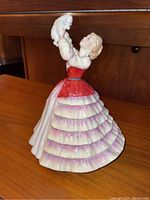 Figurine side angle showing the dress and cat held above the woman's head.