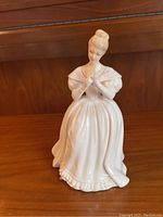 Front view of the Royal Doulton Denise figurine showing the detailed porcelain figure of a woman in a white dress with an updo hairstyle.