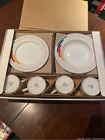 Overview photo showing all plates, bowls, and cups neatly packed in the original box.