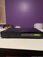 Front view of Yamaha DSP-1 sound processor showing digital display, buttons, and knobs.