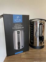 Photo showing the Zulay Kitchen branded product box and the stainless steel coffee urn with water level window.