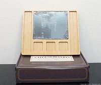 Main cheese board with square slate center and four small compartments, placed on top of the product box