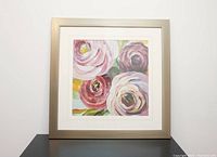 Square pink floral watercolour print framed with wide silver frame and white matting, resting on a flat surface against a plain background.
