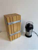 Knife block and coffee grinder side by side on table showing full lot.