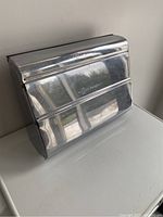 Full view of the retro chrome dispenser with hinged closure and serrated edge