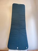 Full view of the blue Quechua self-inflating mattress laid out flat showing overall shape and texture.