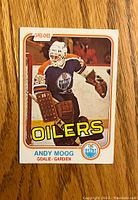 Front view of 1981-82 O-Pee-Chee Andy Moog rookie hockey card showing goalie in Oilers uniform.