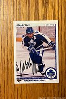 Front of the hockey card showing Wendel Clark in Toronto Maple Leafs uniform with autograph.