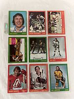 Front view of nine 1973-74 O-Pee-Chee hockey cards laid flat showing player photos and team info