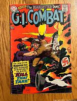 Front cover of G.I. Combat comic book issue #127 showing dramatic wartime scene with soldier and burning tank