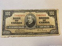 Full front view of 1937 Bank of Canada 100 dollar bill showing portrait and red serial number B3007083