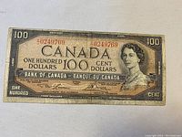 Full front view of banknote showing Queen Elizabeth II portrait and red serial number