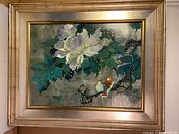 Full view of framed acrylic and silver foil painting showing a large purple and white flower with green leaves and two small birds on a branch. Artist signature visible on lower right.