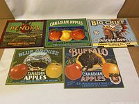 Lot of five vintage Canadian apple crate labels featuring various brands and colorful illustrations of apples and orchards.