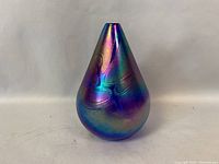 The vase shown from the front highlighting the iridescent color shifts and embossed swirl pattern.