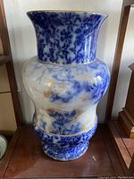 Front view of the large Doulton vase showing blue and white marbled glaze with gold accents.