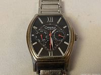 Front close-up of the Caravelle by Bulova men's watch with black dial and Roman numerals, showing subdials and silver-tone hands.
