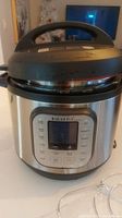 Front view of Instant Pot Duo Nova showing digital control panel, lid and handle.