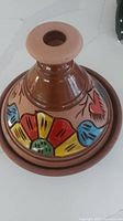 Top view of the Egyptian ceramic tagine with colorful flower and heart patterns on the conical lid.