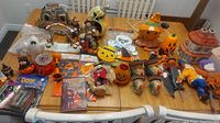 Overview photo showing the entire Halloween and fall decoration lot arranged on a table including haunted house, pumpkin figurines, scarecrows and party supplies.